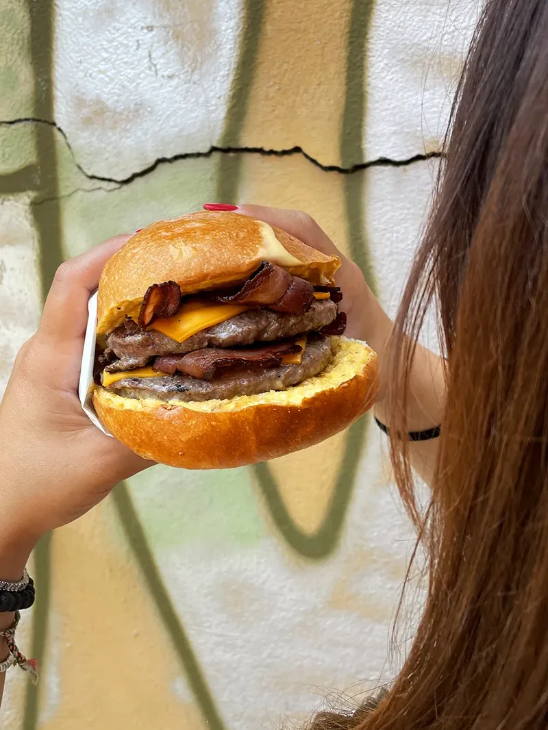 Buono burger, l'hamburgeria gourmet d'asporto e Domicilio di Bologna e Modena. In Foto il Maxi buon con doppio hamburger di scottona da 120 grammi, doppio cheddar, doppio bacon e fonduta di cheddar servito con patatine incluse.